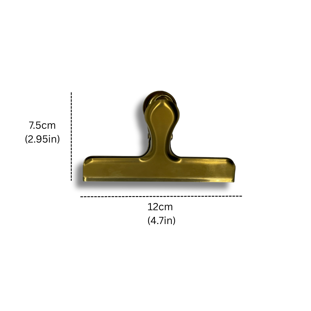 Gold stainless steel sheet music clip shown with dimensions — 12cm wide by 7.5cm tall (4.7in x 2.95in) — ideal for holding sheet music securely during practice or performance.